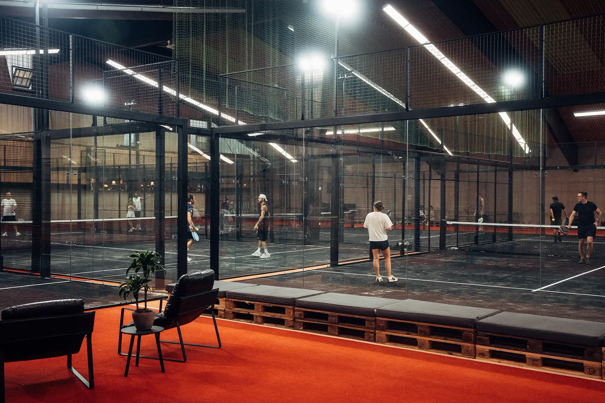 Courts mit Spielern und Lounge in der PADEL72-Halle
