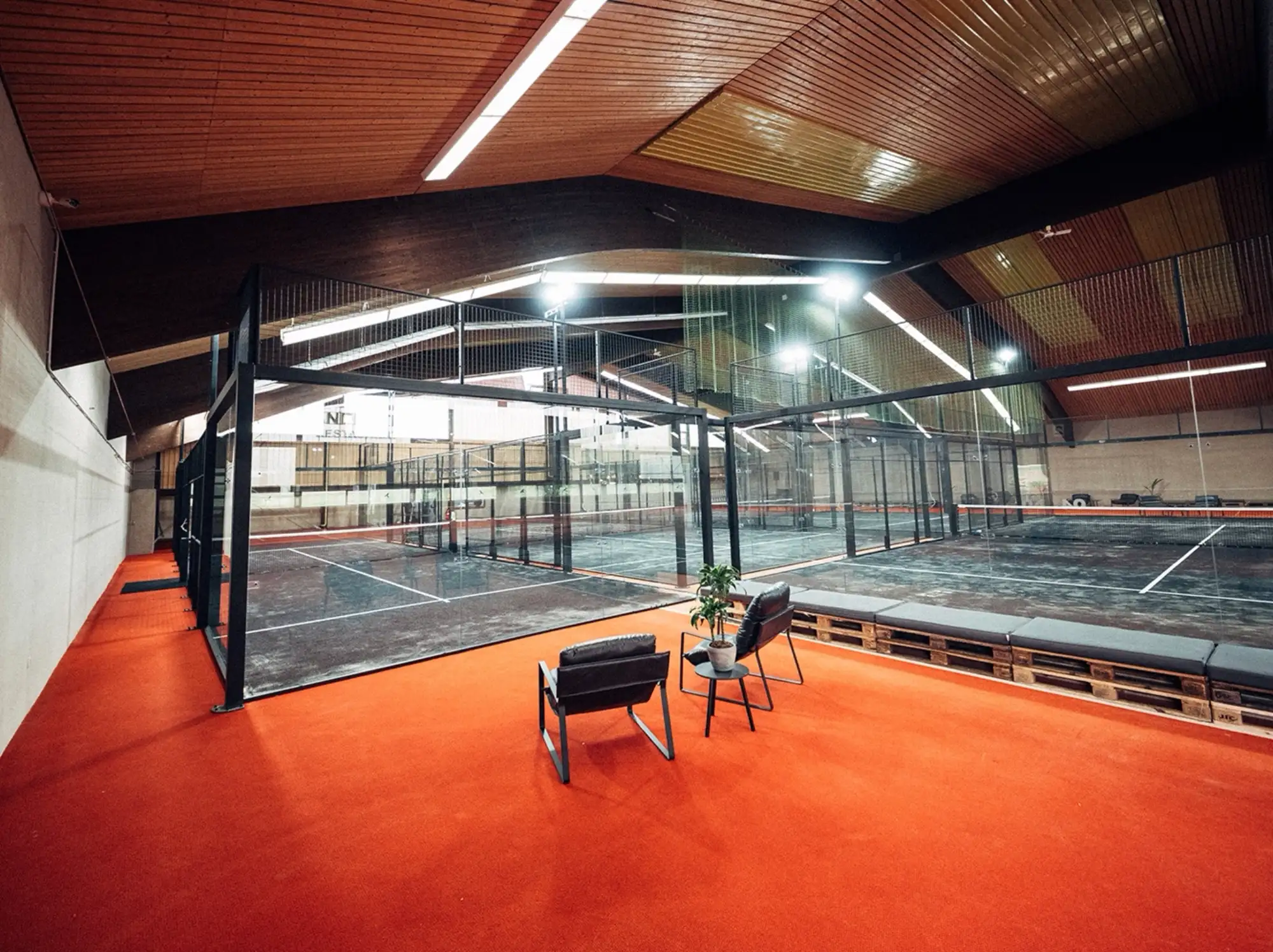 Lounge mit Sesseln und Blick auf die Courts von PADEL72