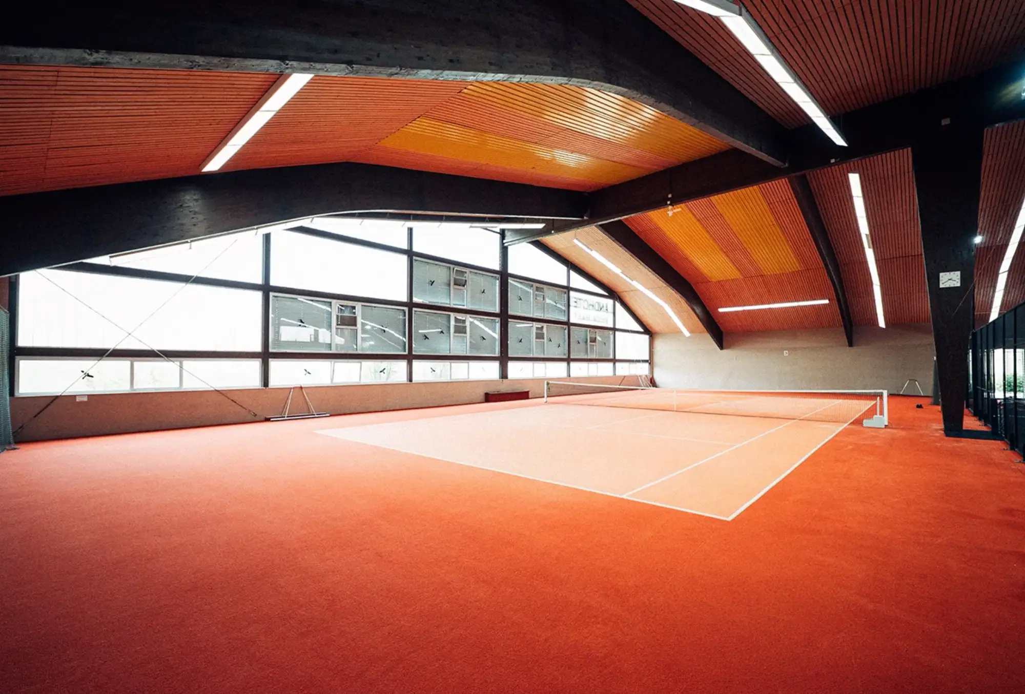 Tennis-Court mit orangefarbenem Boden in der Halle von PADEL72