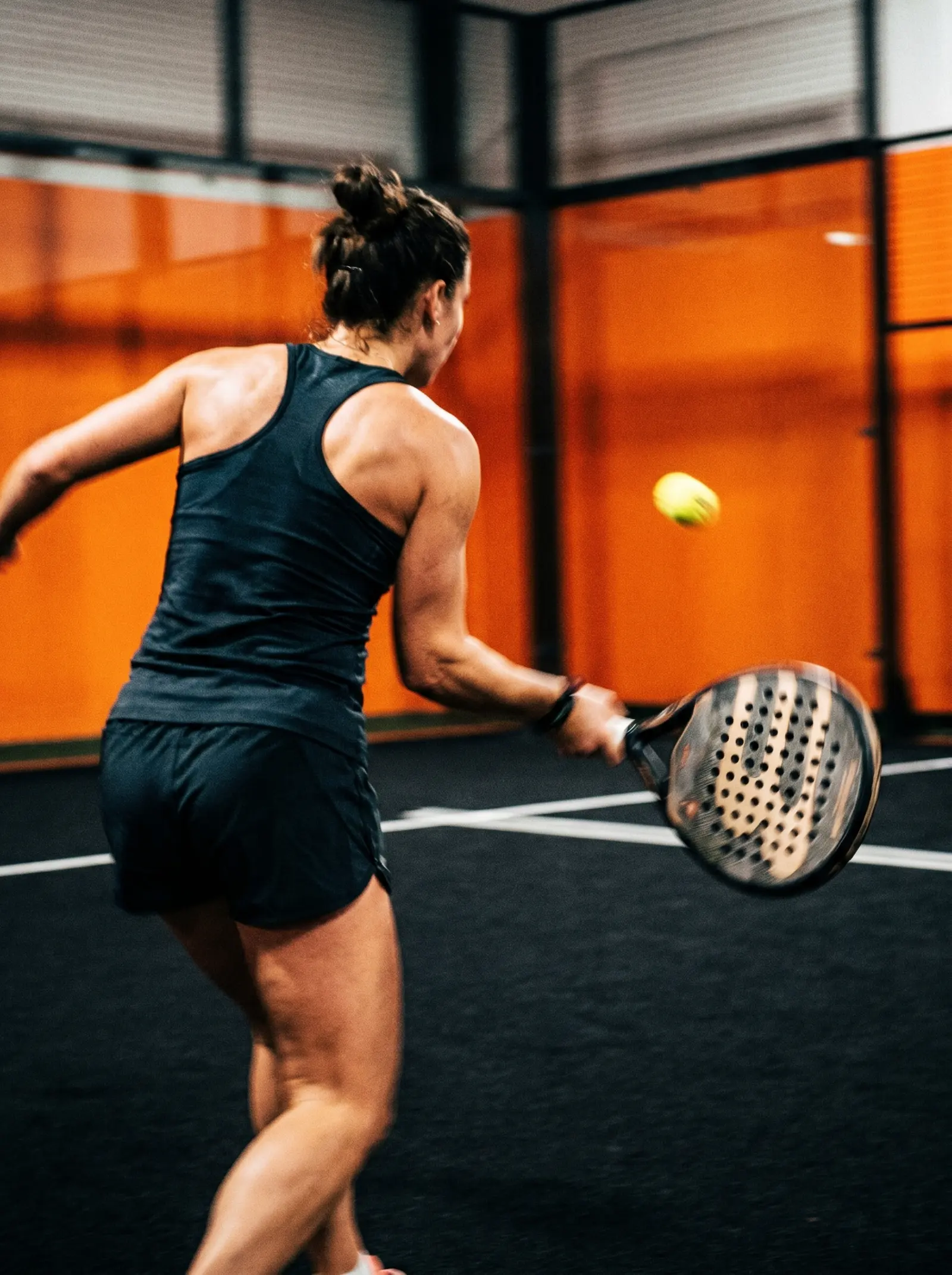 Weißer Padel-Schläger auf der Linie des schwarzen Courts